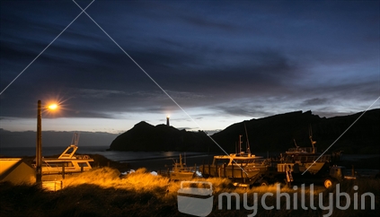 Day break at the Castlepoint Lighthouse where large fishing boats wait for high tide to cross the bar. Castle Point lighthouse is situated on the Wairarapa Coast, about 70 kilometres east of Masterton