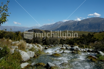 Stream flowing into Rangitata River, Canterbury with New Zealand mountains in the background.