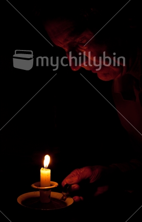 Face looking at burning candle at night