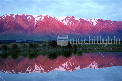 Mt Hutt at sunrise reflected in a lake, New Zealand