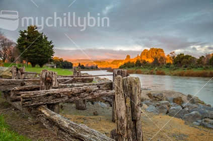 The Manawatu River at sunset, with old wooden structure in the foreground