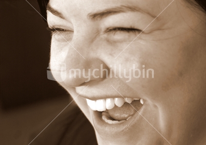 Sepia close up of a woman laughing