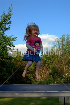 young girl jumping on a trampoline.