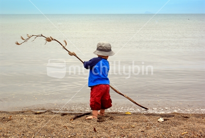 Boy Playing with Flax at Lake Taupo, New Zealand