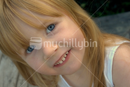 Close up of a strawberry-blonde preschooler smiling