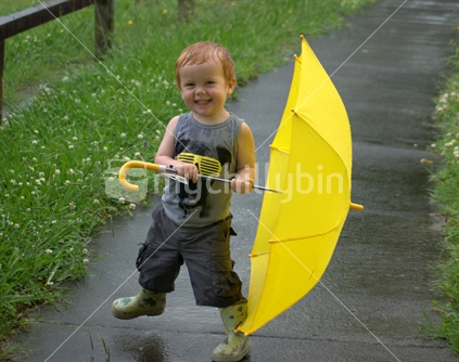 A young boy dances in the rain