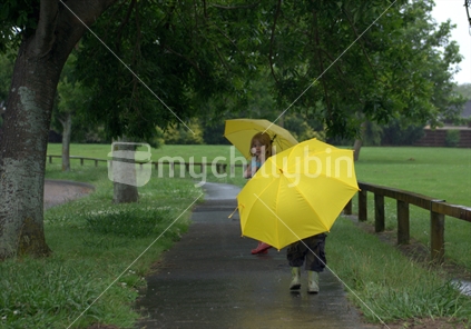 Young children walking in the rain