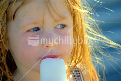 A young New Zealand girl eating an iceblock