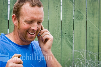 A Kiwi Builder takes a call on his cellphone