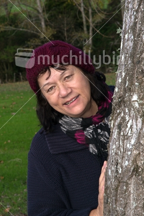 Mature lady standing by a tree