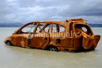 Wrecked car abandoned polluting Kaipara Harbour waterway