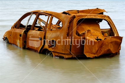 Wrecked car abandoned polluting Kaipara Harbour waterway