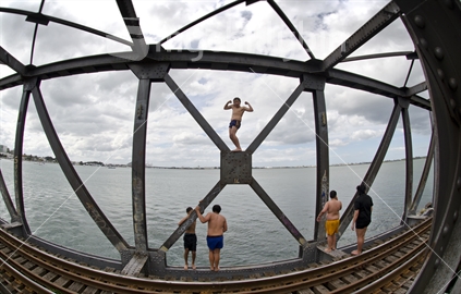 Maori kids jumping into Tauranga Harbour, from the railway bridge 