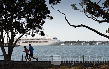 Two joggers watching Cruise ship departing Auckland Harbour