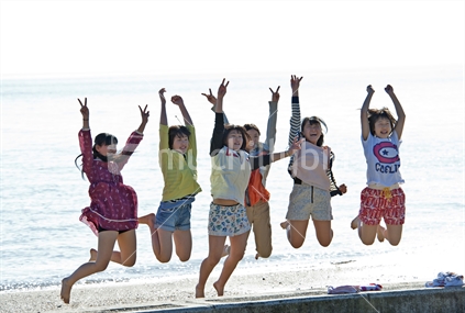 Tourist girls jumping for fun on an Auckland beach (believed to be Korean)