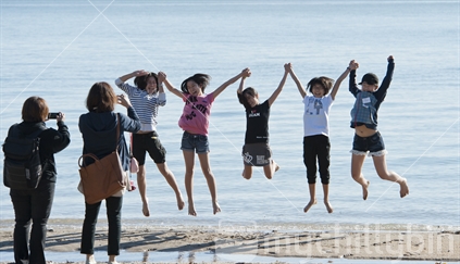  Tourist girls jumping for fun on an Auckland beach (believed to be Korean) 