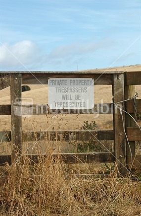 'Trespassers will be prosecuted' sign on farm fence