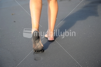 Feet walking in black sand