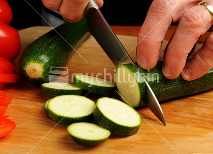 Chef chopping red pepper and courgettes