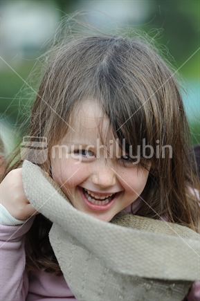 Little girl laughing, playing with sun hat