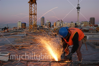 Workman using grinder on building site in Auckland, New Zealand