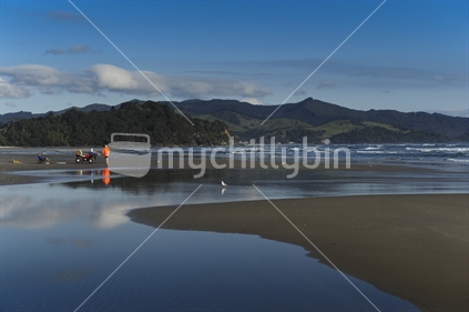 Family fishing on Matarangi Beach, New Zealand