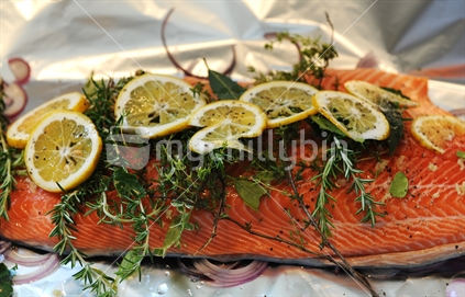 Salmon fillet in tin foil, covered in fresh herbs