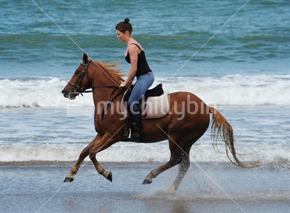 Girl on Horseback galloping on beach