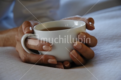 Two Hands nestling white coffee cup