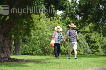 Elderly couple walking through Park, holding Hands