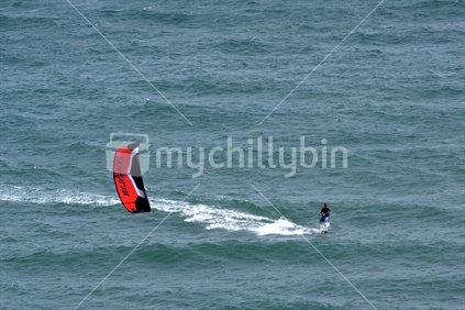 A New Zealand kite surfer rides the waves in a strong northerly wind