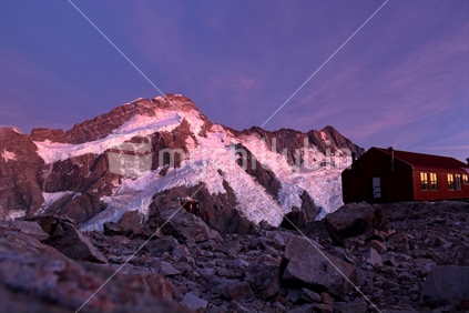 Last light of day reflects off hanging glaciers and the windows of Mueller Hut