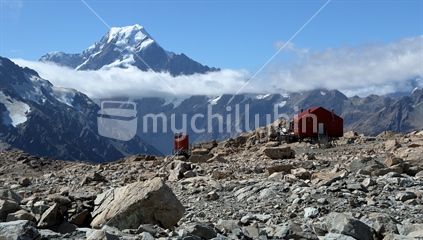 Mueller Hut (and toilet) looking across to Mt Cook/Aoraki, piercing the cloud layer