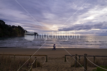 Two women taking an early morning walk along Orewa Beach, north of Auckland, New Zealand