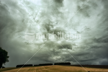 Storm over a mown field, South Island, New Zealand.