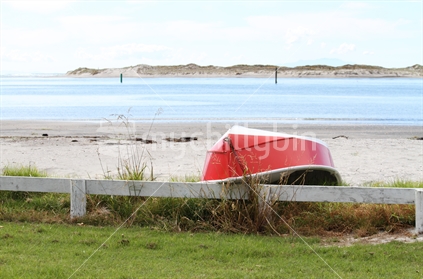 Red dinghy on sandy beach, Mangawhai Heads, New Zealand 