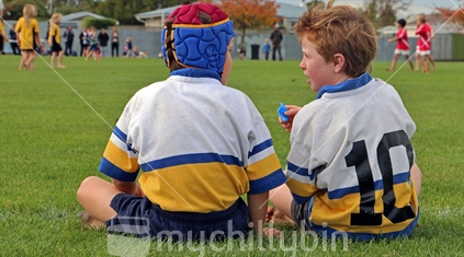 Two young boys discussing rugby game tactics.