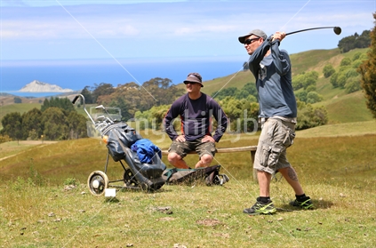 Brothers playing golf on a farm course in Hawkes Bay overlooking Bare Island, and the ocean