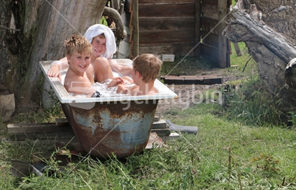 Three brothers sharing an old bath on the farm