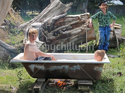 Two brothers having a hot spa bath outside on a farm