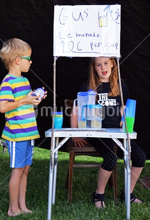 Kids selling lemonade at local gathering