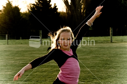 Girl dancing in a field, New Zealand