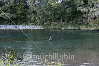 Fishing in the Tongariro near Turangi. A long angler fly fishing in clear waters hoping for a strike
