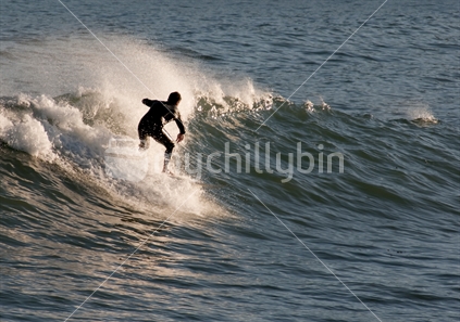 Surfers catch waves in the late afternoon at Wellington's Lyall Bay.