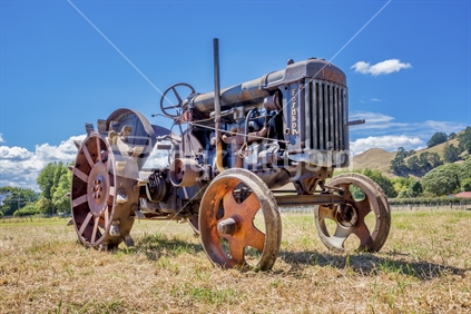 A restored vintage tractor on display in a paddock