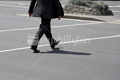 Man in a business suit crossing the road.