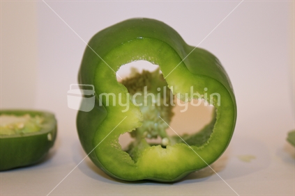 Green pepper capsicum on white background cut open (focus front cut surface)