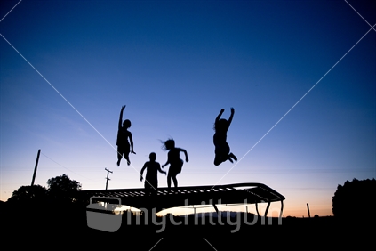 Girls bouncing on trampoline.