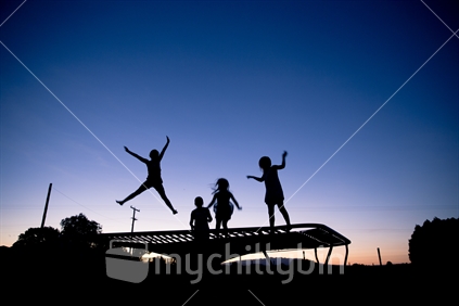 Girls bouncing on trampoline.