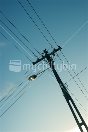 Silhouette of power pole in afternoon sky.